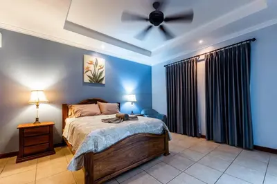 a bedroom with a bed with a ceiling fan at Villa Brisa Del Mar by Vacation Pura Vida in Esterillos