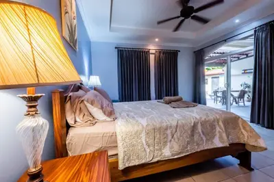 a bedroom with a bed and a table with a lamp at Villa Brisa Del Mar by Vacation Pura Vida in Esterillos