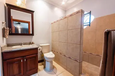 a bathroom with a shower and a toilet and a sink at Villa Brisa Del Mar by Vacation Pura Vida in Esterillos