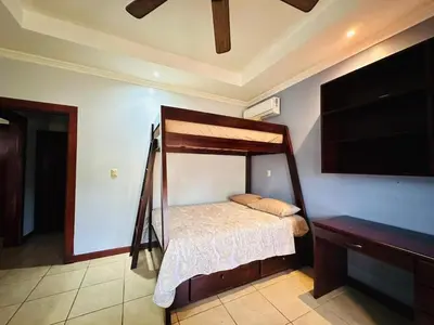 a bedroom with a canopy bed and a tv at Villa Brisa Del Mar by Vacation Pura Vida in Esterillos