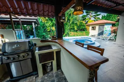 a kitchen with a stove and a swimming pool at Villa Brisa Del Mar by Vacation Pura Vida in Esterillos