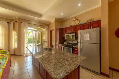 a kitchen with a refrigerator and a counter top at Villa San Miguel by Vacation Pura Vida in Bejuco