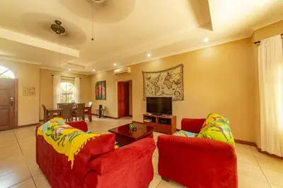 a living room with two red couches and a tv at Villa San Miguel by Vacation Pura Vida in Bejuco