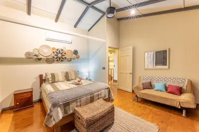 a bedroom with a bed and a couch at Villa Tenga Paz by Vacation Pura Vida in Esterillos