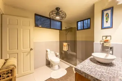 a bathroom with a toilet and a sink at Villa Tenga Paz by Vacation Pura Vida in Esterillos
