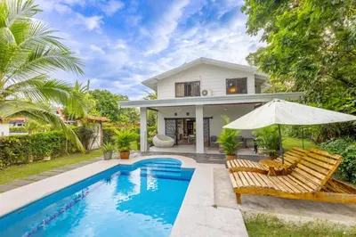 a villa with a swimming pool and a house at Villa Tenga Paz by Vacation Pura Vida in Esterillos