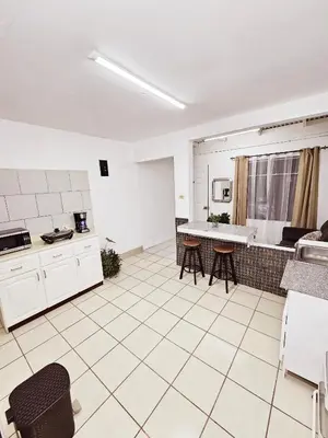 a large kitchen with white cabinets and a table at Apartamento SamSay II in Cartago