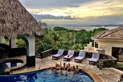a group of people sitting in a swimming pool at Villa Pura Vida - All Inclusive in Ocotal