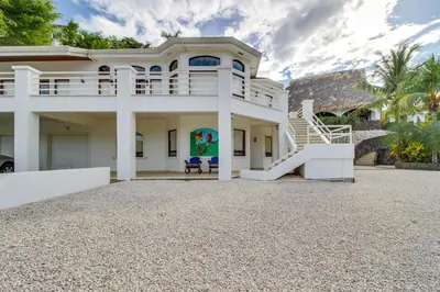 a white house with a staircase in front of it at Villa Pura Vida - All Inclusive in Ocotal