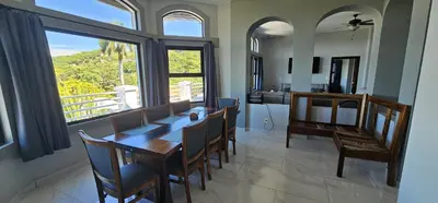 a dining room with a table and chairs and a kitchen at Villa Pura Vida - All Inclusive in Ocotal