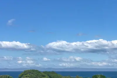 a blue sky with clouds and trees and the ocean at Villa Pura Vida - All Inclusive in Ocotal