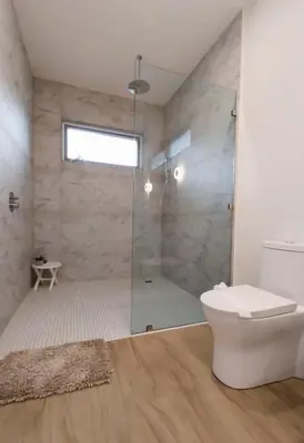 a bathroom with a glass shower and a toilet at Casa Arribada- Bright 4Br House 5-min walk to Beach, Pool, BBQ in Playa Flamingo