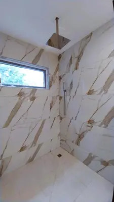 a bathroom with white marble walls and a window at Casa Arribada- Bright 4Br House 5-min walk to Beach, Pool, BBQ in Playa Flamingo