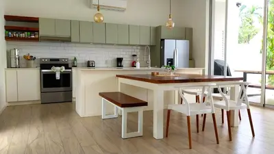 a kitchen with a table and some chairs in it at Casa Arribada- Bright 4Br House 5-min walk to Beach, Pool, BBQ in Playa Flamingo