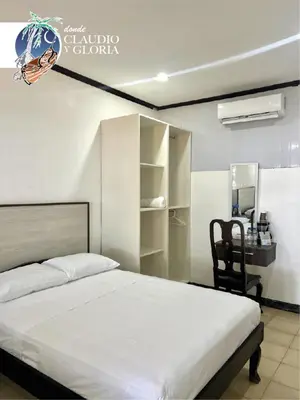a bedroom with a bed and a desk and a chair at Hotel Claudio y Gloria in Coco