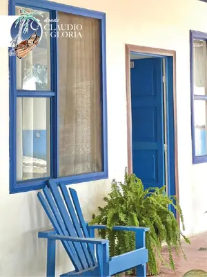a blue chair sitting outside of a house with a blue door at Hotel Claudio y Gloria in Coco
