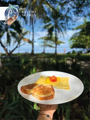 a person holding a plate with breakfast food on it at Hotel Claudio y Gloria in Coco
