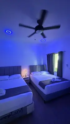 a bedroom with two beds and a ceiling fan at H et L in Tortuguero