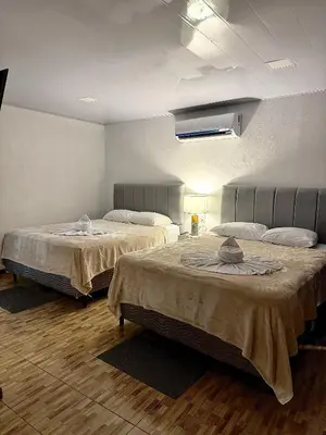 two beds sitting in a room with at H et L in Tortuguero