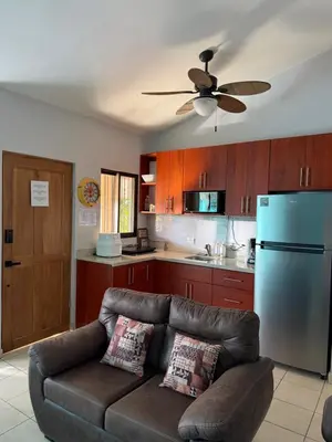 a living room with a couch and a blue refrigerator at Happy Oasis Second Floor Condo with Terrace in Coco