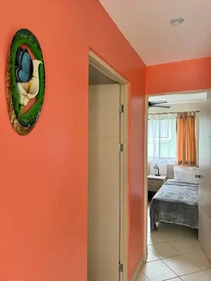 an orange room with a bed and a mirror at Sandy Shore Two bedroom condo across beach in Coco