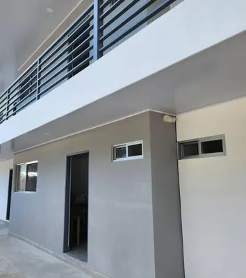 a white building with a staircase on top of it at SamaraLofts near town and beaches in Sámara