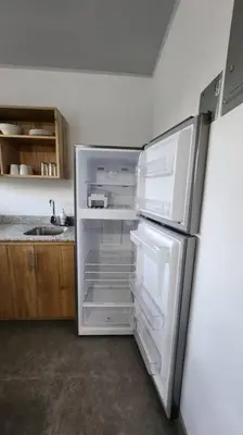 an empty refrigerator with its door open in a kitchen at SamaraLofts near town and beaches in Sámara