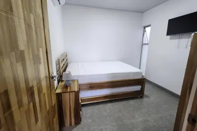 a bedroom with a bed and a wooden door at SamaraLofts near town and beaches in Sámara