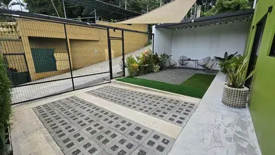a patio with a fence and a yard with plants at Mi casa, tu casa Manuel Antonio, Quepos in Quepos