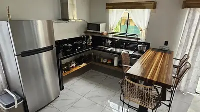 a kitchen with a stainless steel refrigerator and a table at Mi casa, tu casa Manuel Antonio, Quepos in Quepos