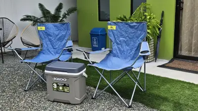 two blue folding chairs and a trash can with a trash can at Mi casa, tu casa Manuel Antonio, Quepos in Quepos
