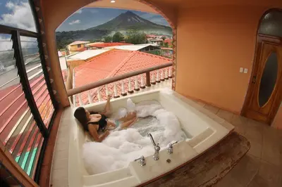 a woman in a bath tub with a view of a mountain at FORTUNA FLAT#2, Luxury & Top View in Fortuna