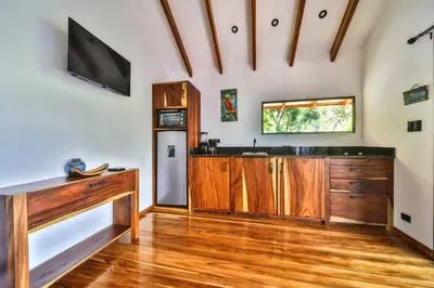 a kitchen with wooden cabinets and a tv on the wall at Beach resort playa Leona in Gigantes