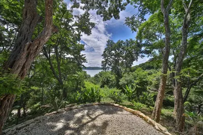 a view of a body of water through a forest at Beach resort playa Leona in Gigantes