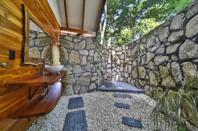 a bathroom with a stone wall and a sink at Beach resort playa Leona in Gigantes