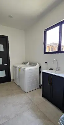 a room with two washing machines and a sink at El Coco Oasis Where Luxury Meets Nature! in Sardinal