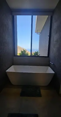a large white bath tub in a bathroom with a window at El Coco Oasis Where Luxury Meets Nature! in Sardinal