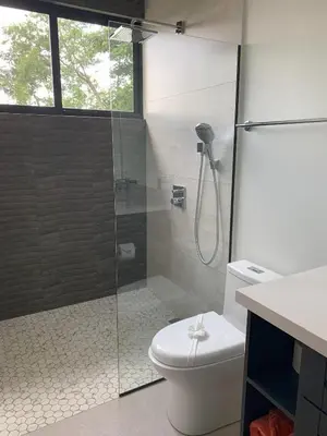 a bathroom with a glass shower with a toilet at El Coco Oasis Where Luxury Meets Nature! in Sardinal