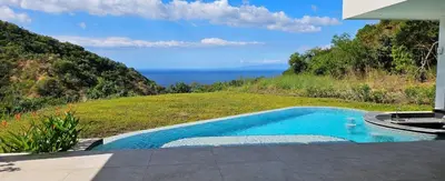 a swimming pool with a view of the ocean at El Coco Oasis Where Luxury Meets Nature! in Sardinal