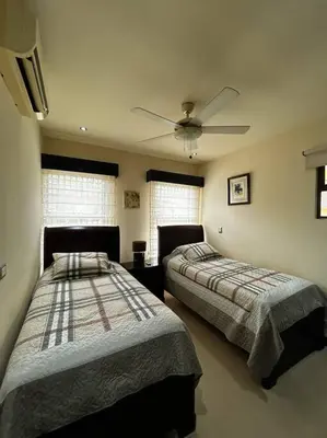 a bedroom with two beds and a ceiling fan at Beautiful Family Villa near Punta Leona in Quebrada Ganado