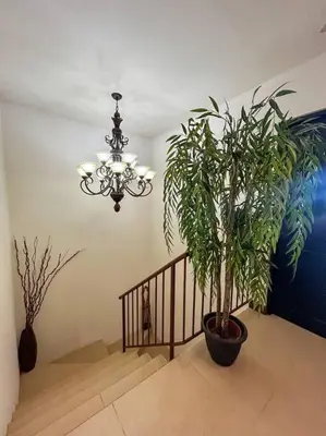 a staircase with a chandelier and a plant in a room at Beautiful Family Villa near Punta Leona in Quebrada Ganado