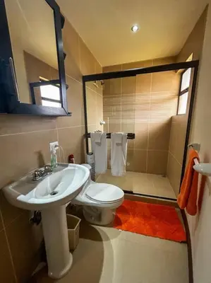 a bathroom with a sink and a toilet and a mirror at Beautiful Family Villa near Punta Leona in Quebrada Ganado