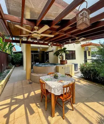 a patio with a table and chairs and a ceiling fan at Beautiful Family Villa near Punta Leona in Quebrada Ganado