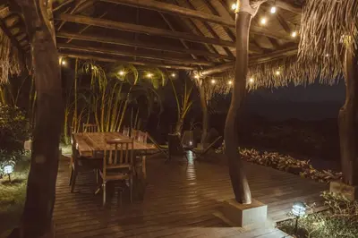 a wooden deck with a table and some lights at Casa Azafan - Amazing Sunsets in Garza