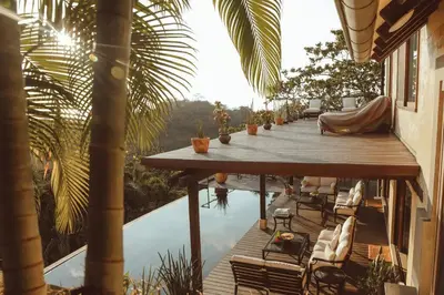 a wooden deck with chairs next to a swimming pool at Casa Azafan - Amazing Sunsets in Garza