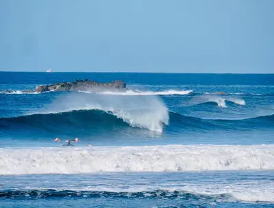 a group of people riding waves in the ocean at Marbella Retreats Casa Azul in Santa Cruz