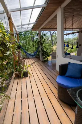 a wooden deck with a hammock on a house at Marbella Retreats Casa Azul in Santa Cruz