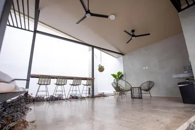 a group of chairs in a room with large windows at Nomad Living CR Tárcoles in Tarcoles