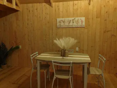 a dining room table with chairs and a vase with feathers at Cabaña Lugar de paz in Villa Mills