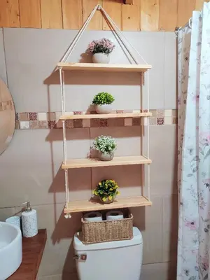 a bathroom with wooden shelves above a toilet with plants at Cabaña Lugar de paz in Villa Mills